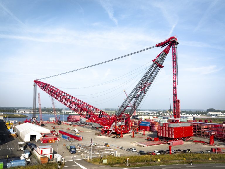 6,000t capacity giant enables faster construction methodologies across the energy sector Mammoet, the largest global engineered heavy lifting and transport company, has today launched the world’s strongest land-based crane, the SK6000. As populations grow, so do our energy needs. The SK6000 re-defines the scale of human construction, allowing large energy and infrastructure projects to build from bigger pieces, in parallel – reaching first power sooner, and more cost-effectively. The SK6000 has a key role in offshore wind, where fast growth of components in recent years has led to supply chain issues. Lifting 3,000t to a height of 220m, the SK6000 ensures that wind farms in the planning phase today can be safely executed and delivered in the future. In the oil and gas sector, the SK6000 delivers reduced integration times to offshore floating projects, while onshore new build and expansion projects can be delivered with increased uptime. Both scopes then benefit from modular construction techniques that allow critical path components to be simultaneously built offsite anywhere in the world, before transporting to site ahead of installation. As more new-build nuclear plants are greenlit, the SK6000 helps the sector to benefit from similar tried-and-tested construction methodologies – helping projects to reach completion sooner and deliver low carbon energy to communities. The SK6000 has a maximum capacity of 6,000t, utilizing 4,200t of ballast to lift with a maximum ground bearing pressure of 30t/m2. The crane design uses containerization techniques for ease of deployment, and can be transported using shipping containers to any location worldwide. It also offers full electric power capability from battery or supply from the grid, allowing customers to reduce the carbon impact of projects significantly. “This crane is truly a world record feat of engineering, with a production schedule to match”, said Gavin Kerr, Director Global Services at Mammoet. “Hundreds of colleagues have been directly involved with its development across the business. There are very few companies on Earth – if any – that could have brought this crane into reality, and we are immensely proud to be able to do so”. The SK6000 is currently undergoing testing at Mammoet’s Westdorpe facility in the Netherlands, ready for deployment to its first project later in the year.