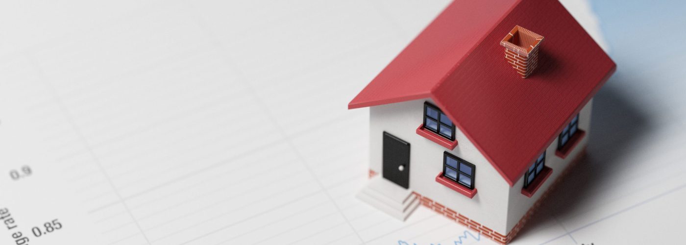 High quality 3d render of a miniature house on a blue financial chart. Housing market concept. Miniature house is lit by the upper left corner of composition. Horizontal composition with copy space. Great use for real estate and morgage related concepts.